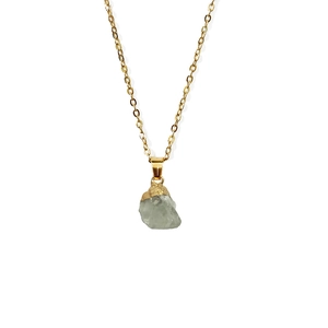 Macro-detail van groene edelsteen ketting met goudkleurige metalen randafwerking