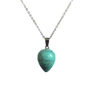 Detail of teardrop turquoise stone pendant with silver chain on a white background
