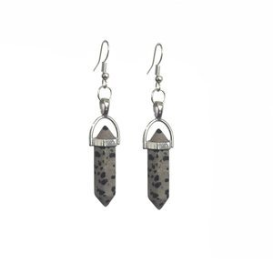 Detail of dalmatian jasper hexagonal column earrings with silver hooks and natural patterns