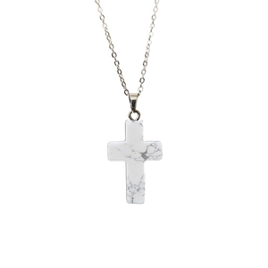 Vue détaillée du pendentif croix en pierre naturelle avec marbrures grises et chaîne argent