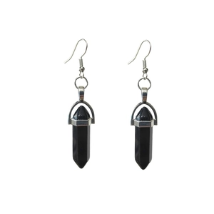 Detail view of black hexagonal stone earrings with silver hooks on white background