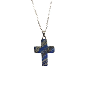 Pendentif croix en pierre de lapis-lazuli avec collier argenté sur fond blanc pur