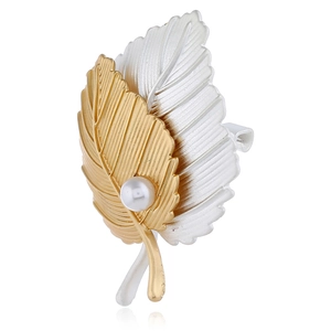 Broche élégante en forme de feuille dorée et argentée avec perle sur fond blanc pur