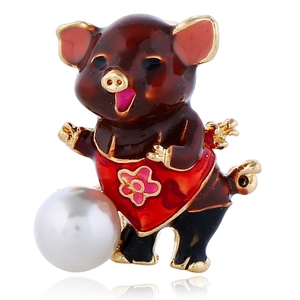 Détail macro d'une broche cochon volant en émail avec ailes dorées et grande perle blanche
