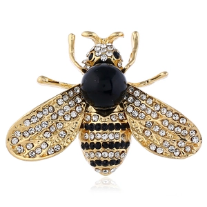 Detailed view of enamel bee brooch with rhinestones and black pearl on white base