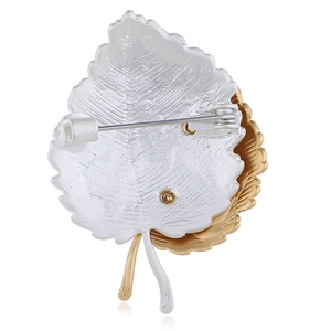 Broche feuille avec perle d'imitation en or et argent montrant l'épingle de sécurité