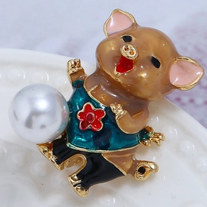Détail d'une broche cochon en émail avec perle blanche et motifs de fleurs rouges