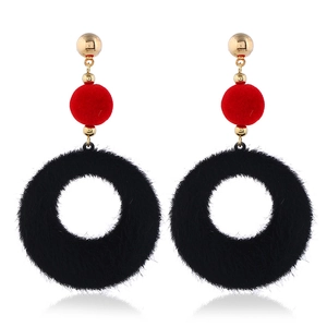 Detail of plush geometric earrings with red and black circles and gold metal studs