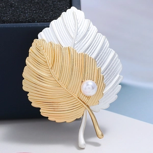 Broche élégante en feuilles d'or et d'argent avec perle sur boîte à bijoux noire