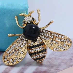 Macro detail of luxury bee brooch with sparkling rhinestones and black enamel bead