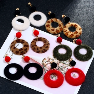 Detailed flat lay of geometric plush circle earrings in various colors and leopard patterns