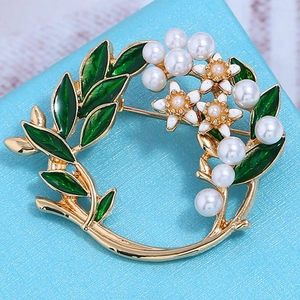 Detailansicht der goldener Blumenkranz-Schalclip mit grünen Blättern und Perlen
