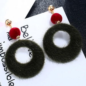 Detail of plush geometric earrings with red flocking and dark green faux fur hoops