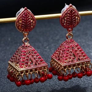 Macro detail of red Jhumka drop earrings with square bell pendants on a stand