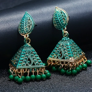 Detailed macro view of bohemian hollow tower earrings with green beads on black background