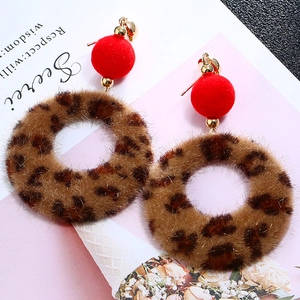Detail of red plush bead earrings with leopard print faux fur circles and gold hoops