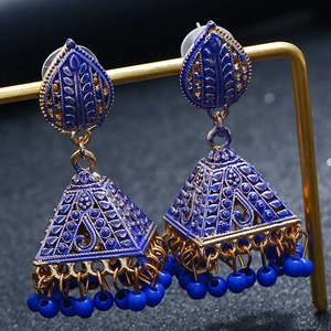 Close-up of bohemian blue enamel Jhumka earrings with golden bell tassels on a display