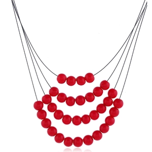 Détail d'un collier de perles à quatre rangs avec sphères rouges et cordons noirs