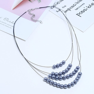 Détail du collier multi-rangs en cordon noir avec perles grises et fermoir mousqueton