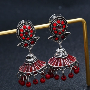 Detailed close-up of retro Jhumka earrings with red enamel and beaded fringe tassels