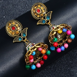 Detailed close-up of bohemian sunflower drop earrings with colorful beads on black texture
