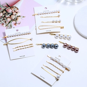 Vue détaillée de barrettes à cheveux en perles et strass sur fond blanc avec fleurs roses