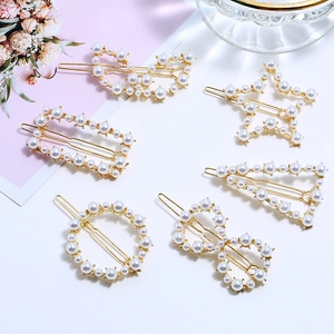 Détail de l'ensemble de barrettes dorées avec perles blanches aux formes géométriques