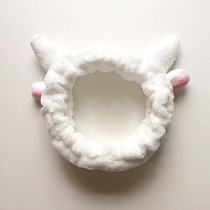 Détail du polaire corail blanc doux et des petites cornes de renne en peluche du bandeau