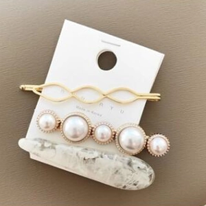 Détail de trois barrettes à perles et texture marbre sur carte de présentation