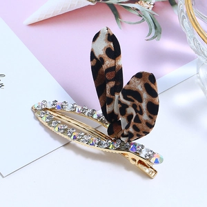Détail de la pince à cheveux à motif léopard avec strass brillants et base dorée chic