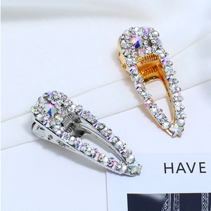 Détail de barrettes à cheveux en strass étincelants avec finition or et argent sur tissu