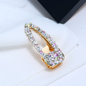 Gros plan détaillé d'une barrette BB dorée avec des strass brillants et une étoile verte