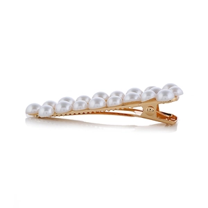 Détail d'une pince à cheveux dorée ornée de deux rangées de perles blanches élégantes