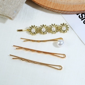 Détail d'un ensemble de 4 barrettes dorées avec fleurs de marguerites et perles