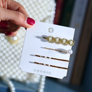 Détail d'un ensemble de 4 pinces à cheveux dorées avec marguerites et perles nacrées