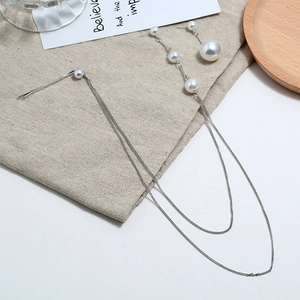 Elegante zilveren oorbellen en haarspeld set met witte parels en lange kwastjes