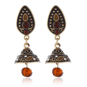 Detail van klokvormige Jhumka oorbellen met rode kristallen en goudkleurig filigraan