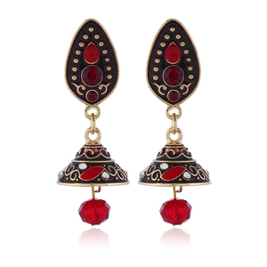 Macro-detail van Boheemse Jhumka-oorbellen met rode kristallen en goudkleurige legering