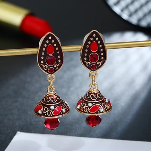 Detailweergave van vintage Jhumka oorbellen met rood emaille en kristallen kralen