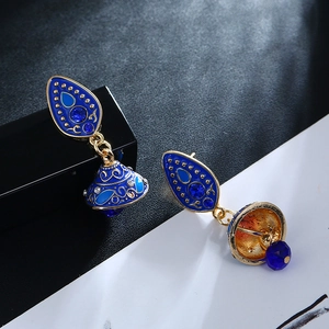 Detail van bohemien druppeloorbellen met blauw emaille, gouden legering en kristallen