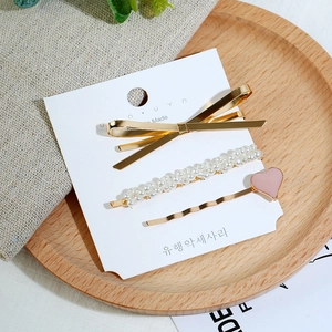 Ensemble de trois pinces à cheveux avec perles blanches et cœur rose sur carte