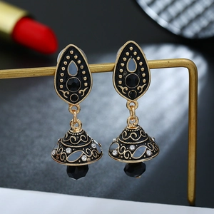 Macro-opname van vintage zwarte en gouden Jhumka-oorbellen met patronen en kristallen