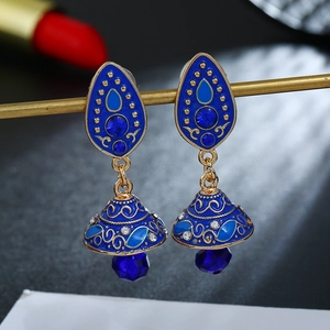 Detailopname van blauwe emaille druppeloorbellen met kristallen en gouden accenten