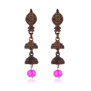 Détail de boucles d'oreilles Jhumka vintage en bronze avec gravures et perles roses éclatantes