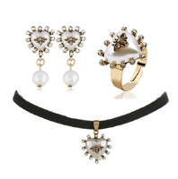 Dettaglio set di gioielli in oro con cuore, rilievo ape e perle eleganti
