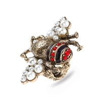 Dettaglio dell'anello ape vintage in bronzo con perle bianche e strass rossi