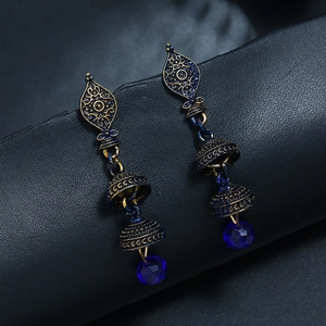 Détail macro de boucles d'oreilles Jhumka vintage avec émail bleu et cloches en bronze