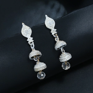 Détail de boucles d'oreilles bohèmes vintage avec cloches blanches et perles claires