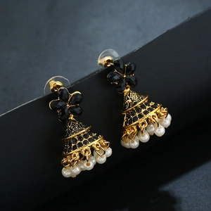 Détail macro de boucles d'oreilles Jhumka vintage noires avec cloche dorée et perles