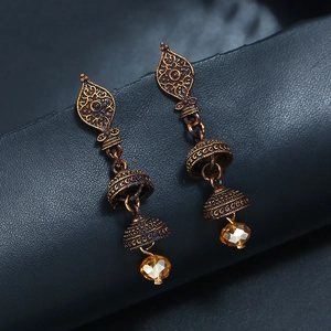 Vue macro de boucles d'oreilles vintage en bronze avec gravures et perles ambrées